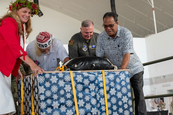 (Left to right), Jennifer Johnson, U.S. Ambassador to the Federated States of Micronesia, Bruce Best, Operation Christmas Drop (OCD) island liaison and coordinator, Lt. Gen. Ricky Rupp, U.S. Forces Japan and Fifth Air Force commander, and His Excellency Wesley Simina, President of the Federated States of Micronesia, push a bundle onto a Yokota Air Base C-130J Super Hercules during the OCD 23 Push Ceremony, Dec. 4, 2023, at Andersen Air Force Base, Guam. OCD is an opportunity to work together, to learn from one another, and to continue successful joint efforts in support of humanitarian aid delivery. (U.S. Air Force photo by Tech. Sgt. Taylor Altier)