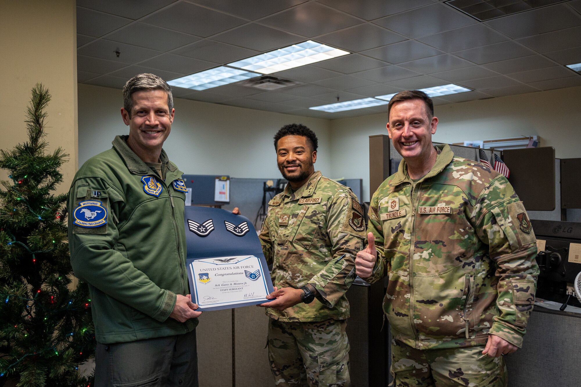 From left, U.S. Air Force Col. William McKibban, 51st Fighter Wing commander, Staff Sgt. Garry Monroe, 51st Civil Engineer Squadron emergency management journeyman, and Chief Master Sgt. Joshua Trundle, 51st FW command chief, pose for a photo following Monroe's receipt of a promotion certificate from the Stripes for Exceptional Performers program at Osan Air Base, Republic of Korea, Dec. 5, 2023. The STEP program is a distinctive promotion initiative that allows commanders to rapidly advance outstanding enlisted members, bypassing standard testing and time requirements. Monroe’s exceptional performance and achievements earned him an immediate promotion to Staff Sergeant through the STEP program. (U.S. Air Force photo by Staff Sgt. Thomas Sjoberg)