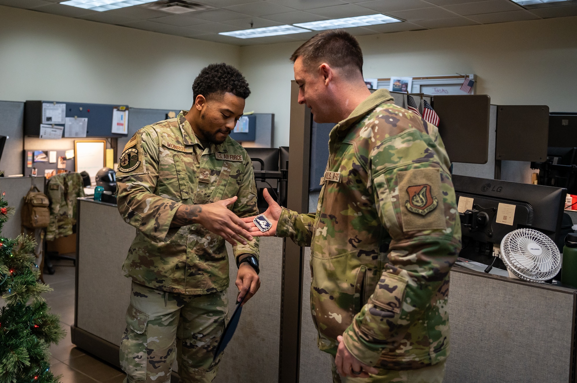 U.S. Air Force Chief Master Sgt. Joshua Trundle, 51st Fighter Wing command chief, coins Staff Sgt. Garry Monroe, 51st Civil Engineer Squadron emergency management journeyman, after his promotion through the Stripes for Exceptional Performers program at Osan Air Base, Republic of Korea, on Dec. 5, 2023. Monroe's exceptional performance and achievements earned him an immediate promotion to Technical Sergeant through the STEP program. (U.S. Air Force photo by Staff Sgt. Thomas Sjoberg)