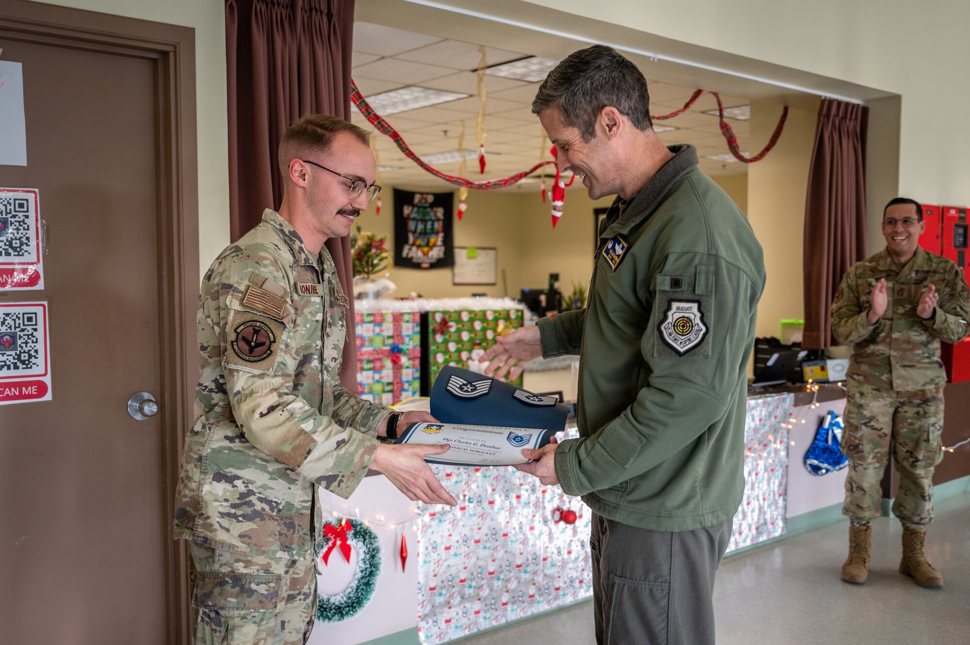 U.S. Air Force Tech. Sgt. Charles Donihue, left, 51st Logistics Readiness Squadron vehicle management flight noncommissioned officer in charge of warfighter support, is presented with a promotion certificate from the Stripes for Exceptional Performers program by Col. William McKibban, 51st Fighter Wing commander, at Osan Air Base, Republic of Korea, on Dec. 5, 2023. The STEP program offers commanders a way to fast-track promotions for exceptionally performing enlisted members, sidestepping the usual tests and waiting periods. (U.S. Air Force photo by Staff Sgt. Thomas Sjoberg)