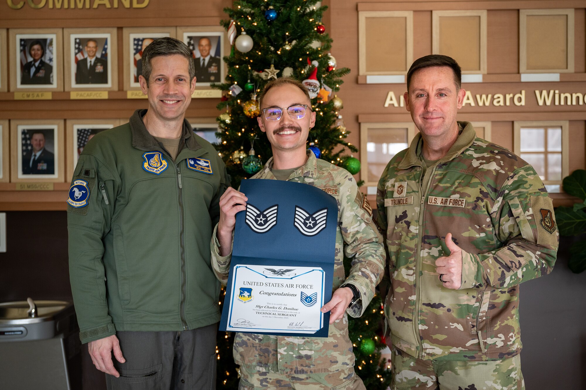 From left, U.S. Air Force Col. William McKibban, 51st Fighter Wing commander, Tech. Sgt. Charles Donihue, 51st Logistics Readiness Squadron vehicle management flight noncommissioned officer in charge of war fighter support, and Chief Master Sgt. Joshua Trundle, 51st FW command chief, pose for a photo following Monroe's receipt of a promotion certificate from the Stripes for Exceptional Performers program at Osan Air Base, Republic of Korea, Dec. 5, 2023. The STEP program enables Wing commanders to directly promote Airmen who have shown outstanding potential and have consistently delivered exceptional performance. (U.S. Air Force photo by Staff Sgt. Thomas Sjoberg)