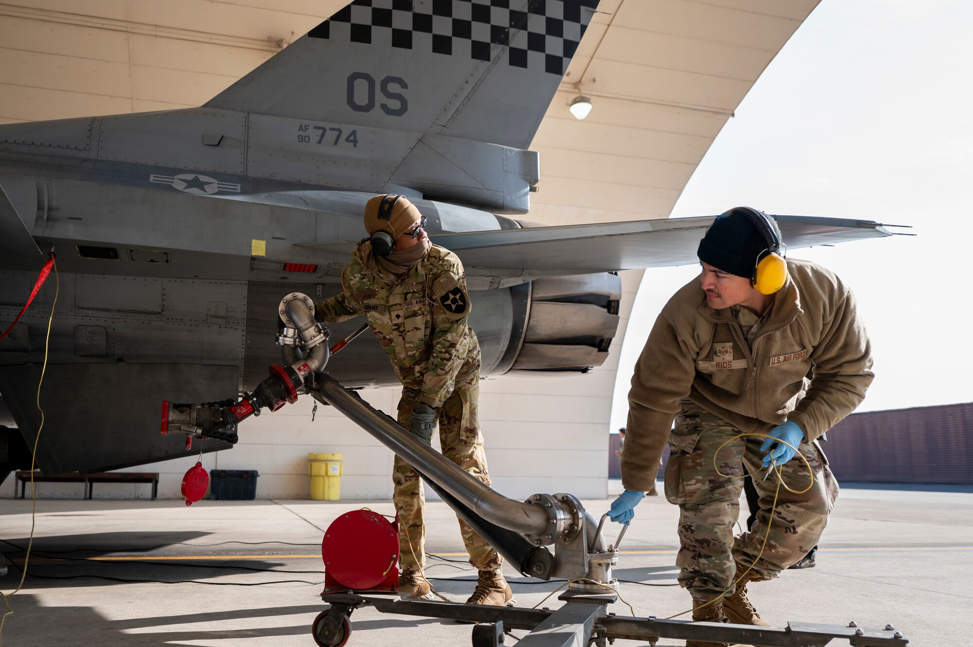 U.S. Army Spc. Marcus Grant, 2nd Infantry Division Sustainment Brigade petroleum supply specialist, and U.S. Air Force Staff Sgt. Antonio Rios, 51st Logistics Readiness Squadron fuels distribution supervisor, perform a hot-pit refuel on an F-16 Fighting Falcon during a joint training event at Osan Air Base, Republic of Korea, Nov. 29, 2023.