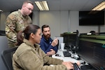 Capt. Ryan Baity, (left) 33d Cyberspace Operations Squadron exercise lead, discusses cyber defense with 1st Lt. Tricia Dang, 834th COS mission element lead and Justin Connelley, 834th COS host analyst, during Cyber Coalition 2023, Joint Base San Antonio, Lackland, Nov. 30, 2023.