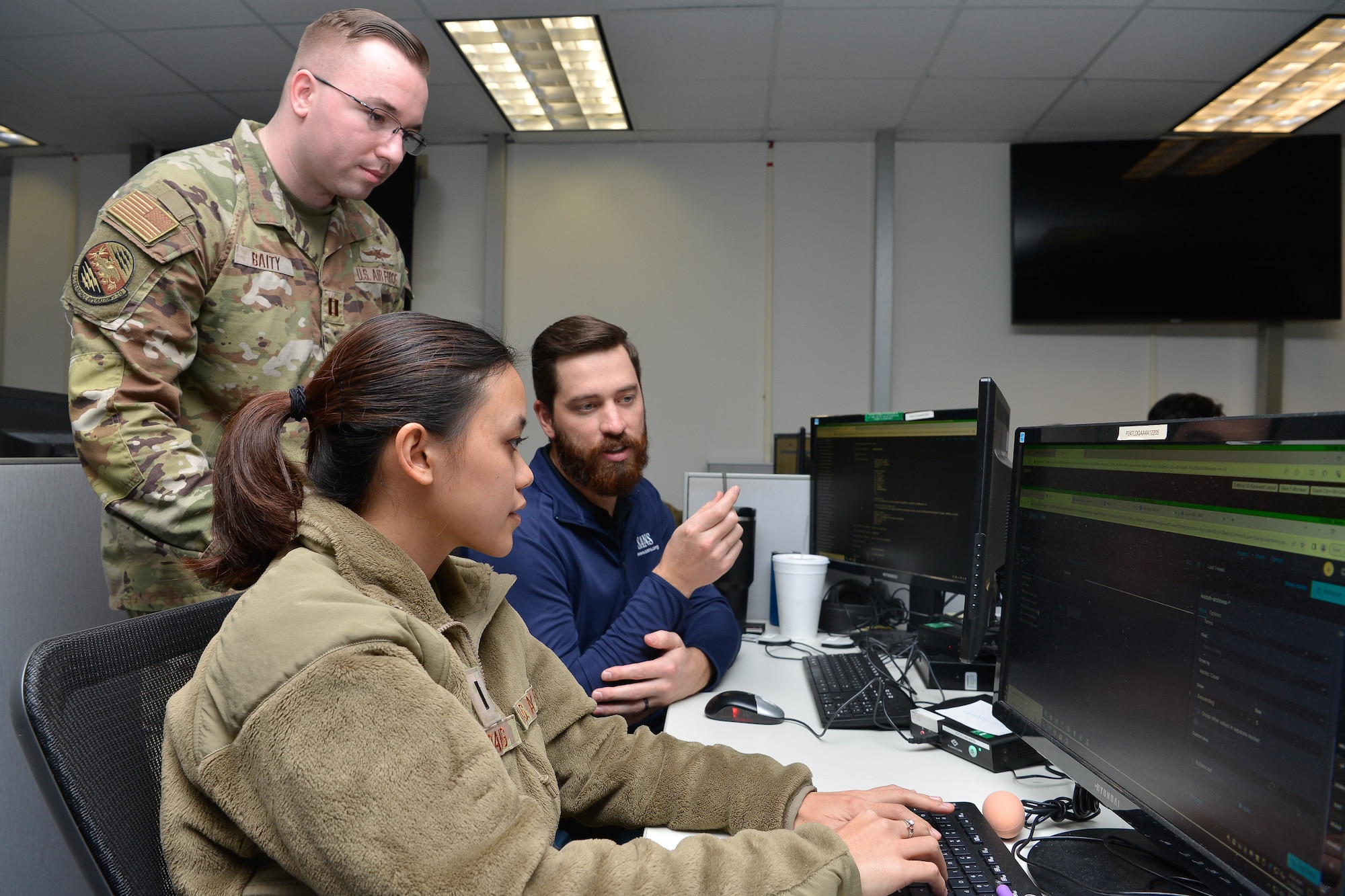 Capt. Ryan Baity, (left) 33d Cyberspace Operations Squadron exercise lead, discusses cyber defense with 1st Lt. Tricia Dang, 834th COS mission element lead and Justin Connelley, 834th COS host analyst, during Cyber Coalition 2023, Joint Base San Antonio, Lackland, Nov. 30, 2023.