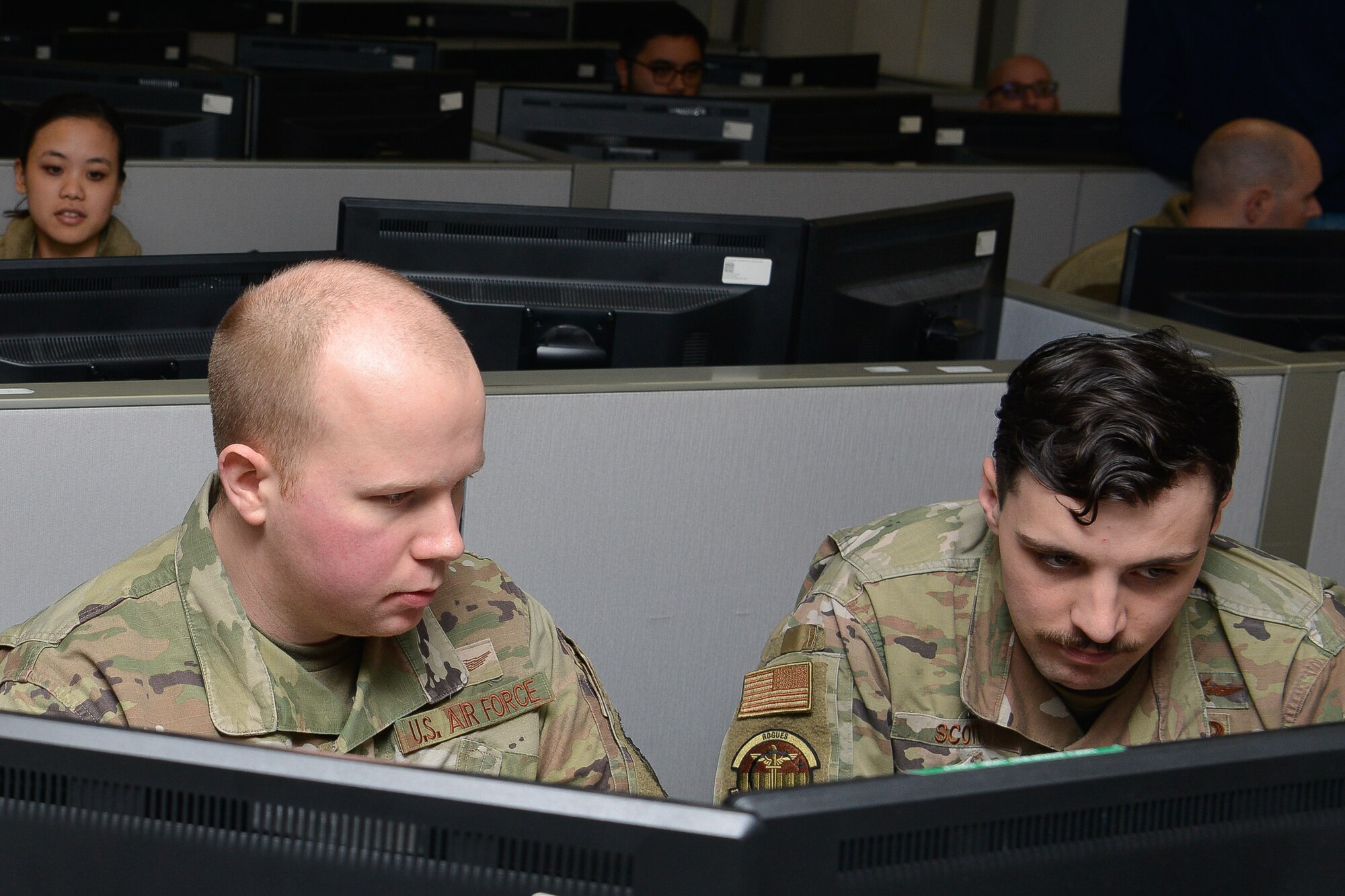 Staff. Sgt. Carter Brazell, 834th Cyberspace Operations Squadron network operator, discusses defensive cyber operations with Senior Airman Luke Scott, 834th COS network operator, during Cyber Coalition 2023 at Joint Base San Antonio, Lackland, Nov. 30, 2023.