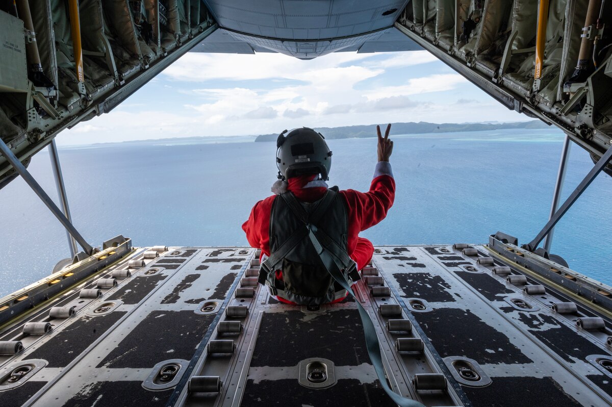 Photo of a  U.S. Air Force Airman sitting on the back of a C-130J