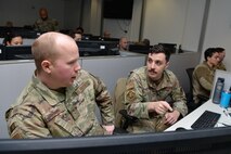 Staff. Sgt. Carter Brazell, 834th Cyberspace Operations Squadron network operator, discusses defensive cyber operations with Senior Airman Luke Scott, 834th COS network operator, during Cyber Coalition 2023, Joint Base San Antonio, Lackland, Nov. 30, 2023.