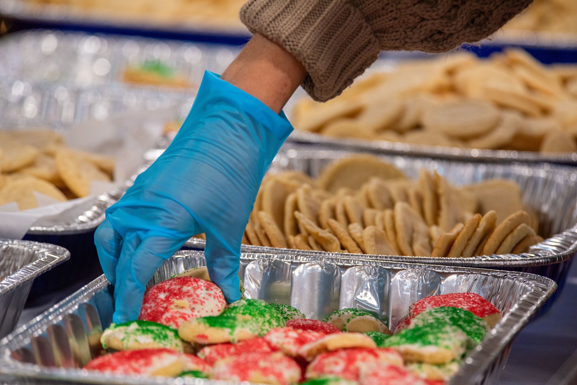 A member of Team Misawa grabs a cookie to package during the annual Cookie Caper at Misawa Air Base, Japan, Dec. 5, 2023.