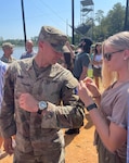 Kentucky Army National Guard 2nd Lt. Dustin McKie-Miller's girlfriend, Army Capt. Carly Schroeder, puts the Ranger Tab patch on his arm after his graduation from Ranger School at Fort Moore, Georgia, Aug. 18, 2023. McKie-Miller aced every challenge of the Ranger training on his first attempt and finished the course in 62 days, the shortest time possible.