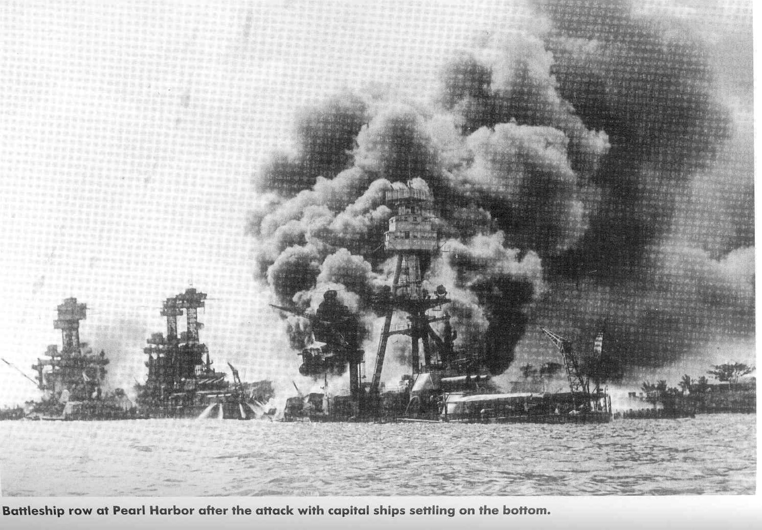 Battleship row at Pearl Harbor after the attack with capital ships settling on the bottom.