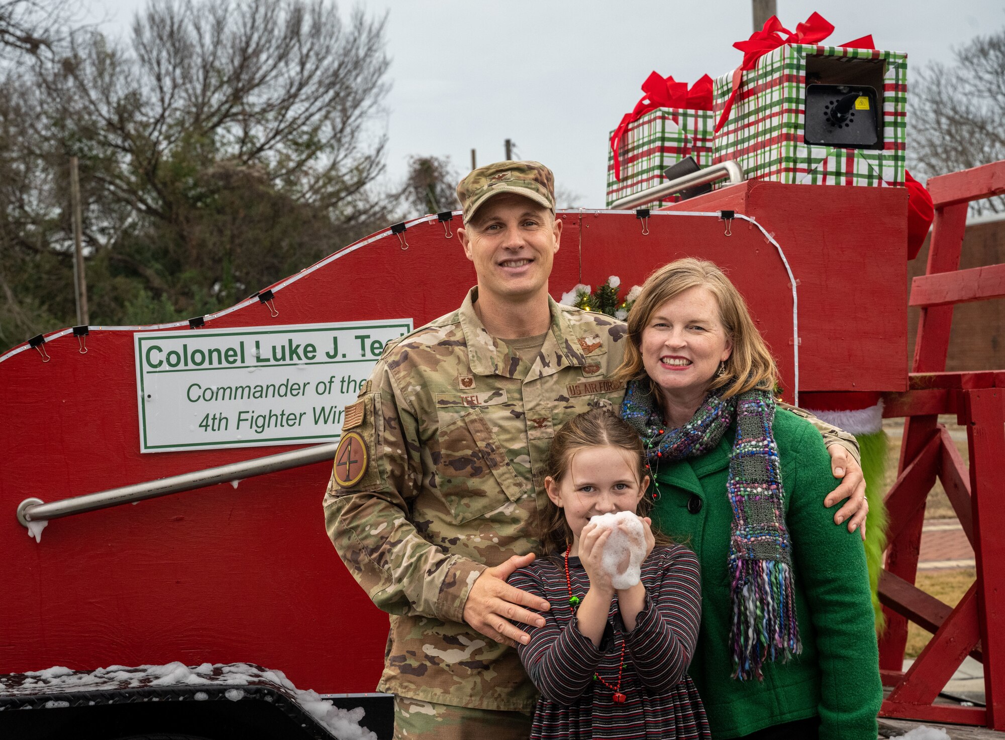 U.S. Air Force Col. Lucas Teel, 4th Fighter Wing commander, his wife, Meghan Teel and daughter, Annie Teel, pose for a photo after the holiday parade in downtown Goldsboro, North Carolina, Dec. 2, 2023. The holiday parade was joined by many different schools, community agencies, civic leaders and Seymour Johnson personnel. (U.S. Air Force photo by Senior Airman Sabrina Fuller-Judd)