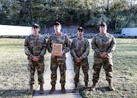Multiple men in U.S. Army uniforms on outdoor range.