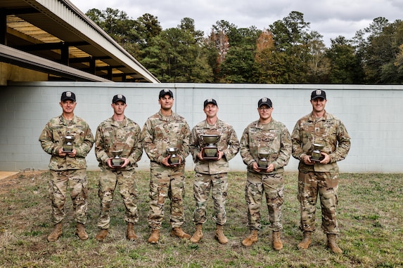 Multiple men in U.S. Army uniforms on outdoor range.