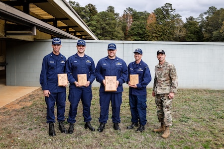 Multiple men in U.S. Coast Guard and U.S. Army uniforms on outdoor range