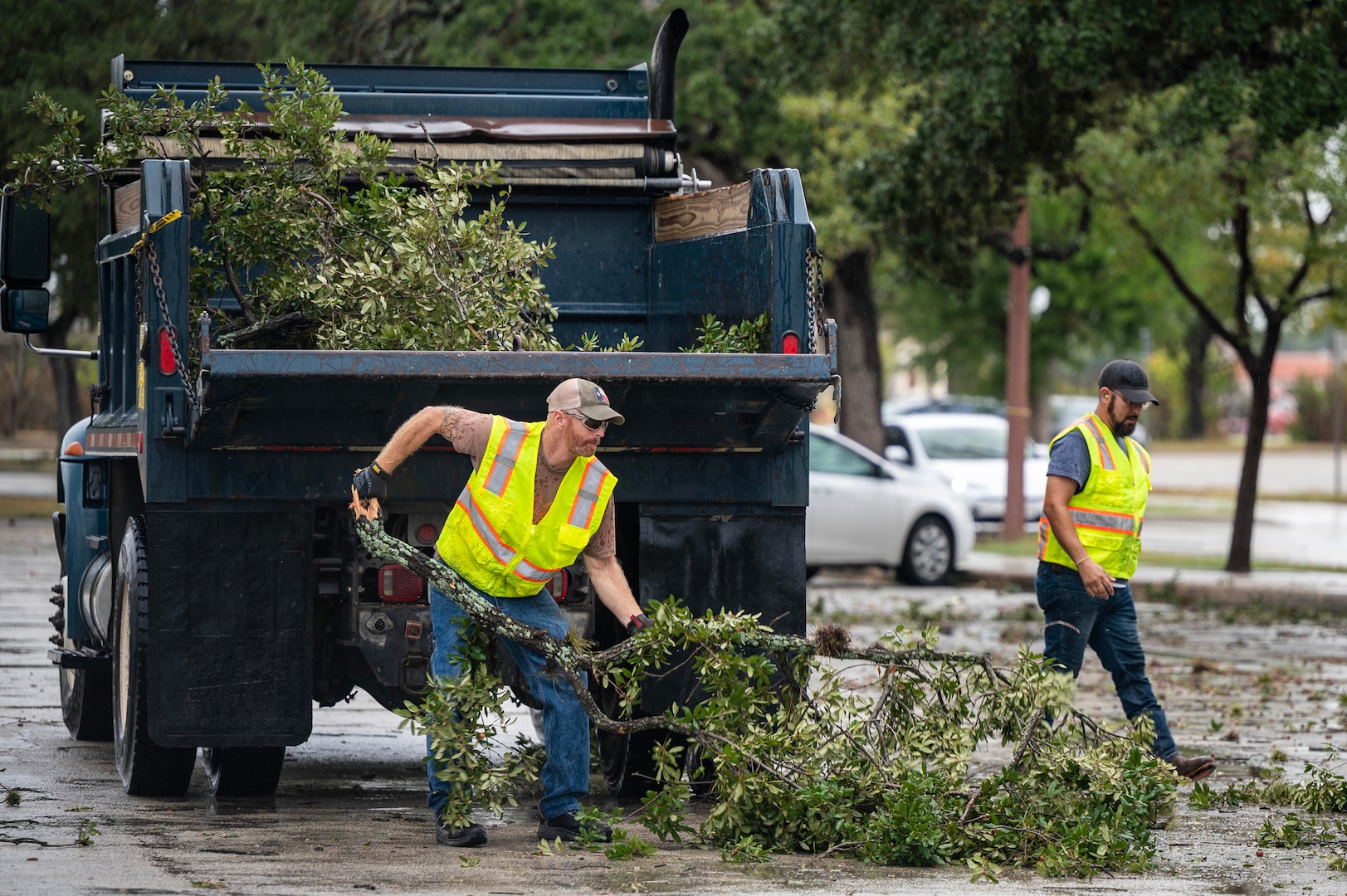 Men picking up downed branches