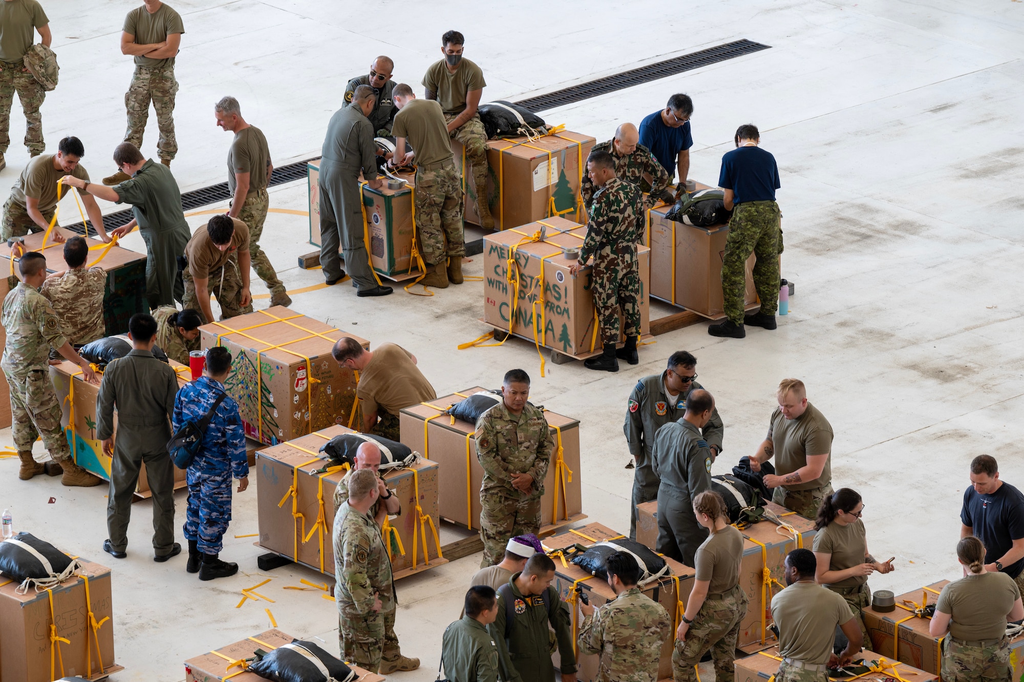 Photo of Operation Christmas Drop 2023 volunteers bundling airdrops.