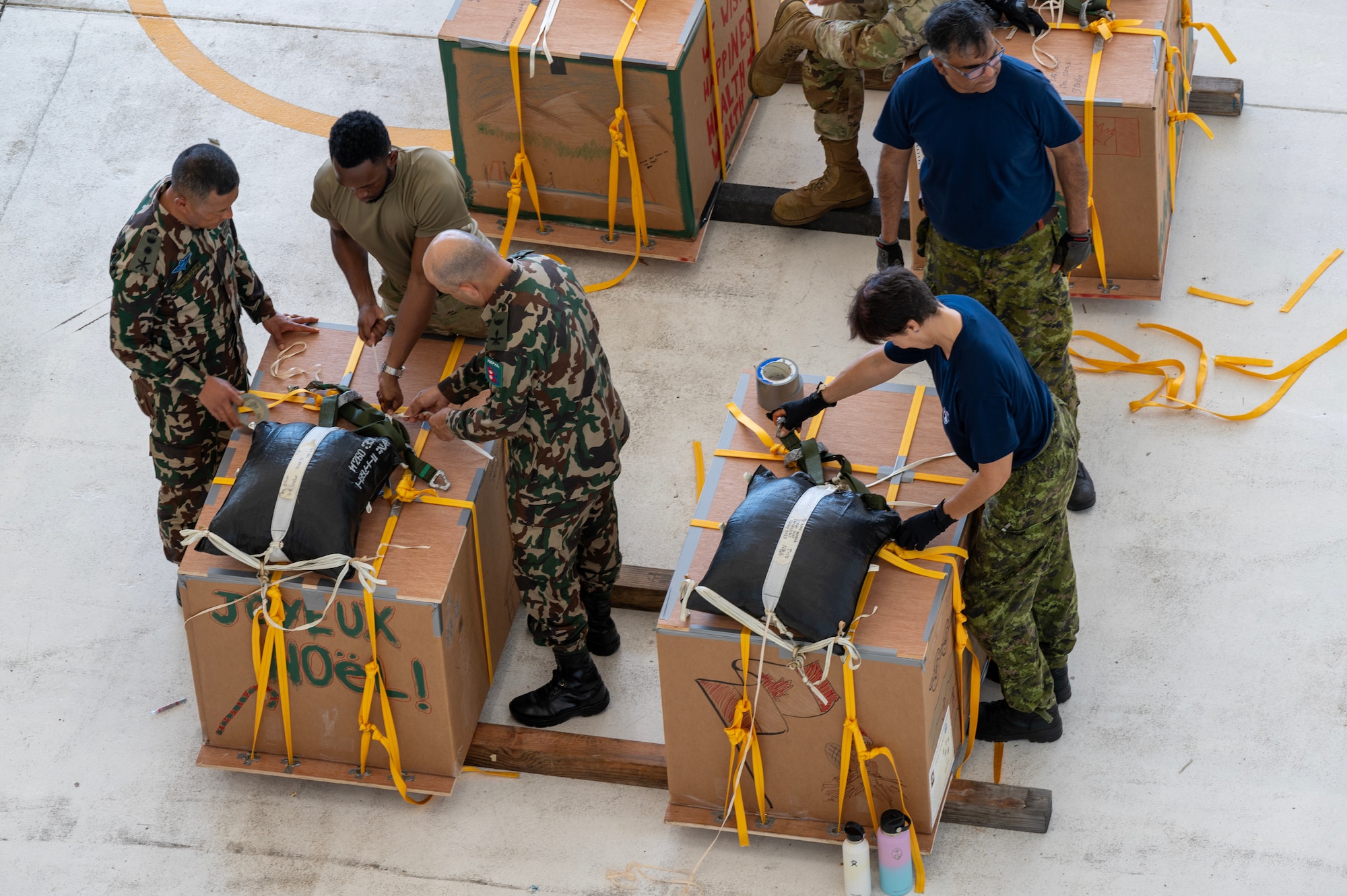 Photo of Operation Christmas Drop 2023 volunteers bundling airdrops.