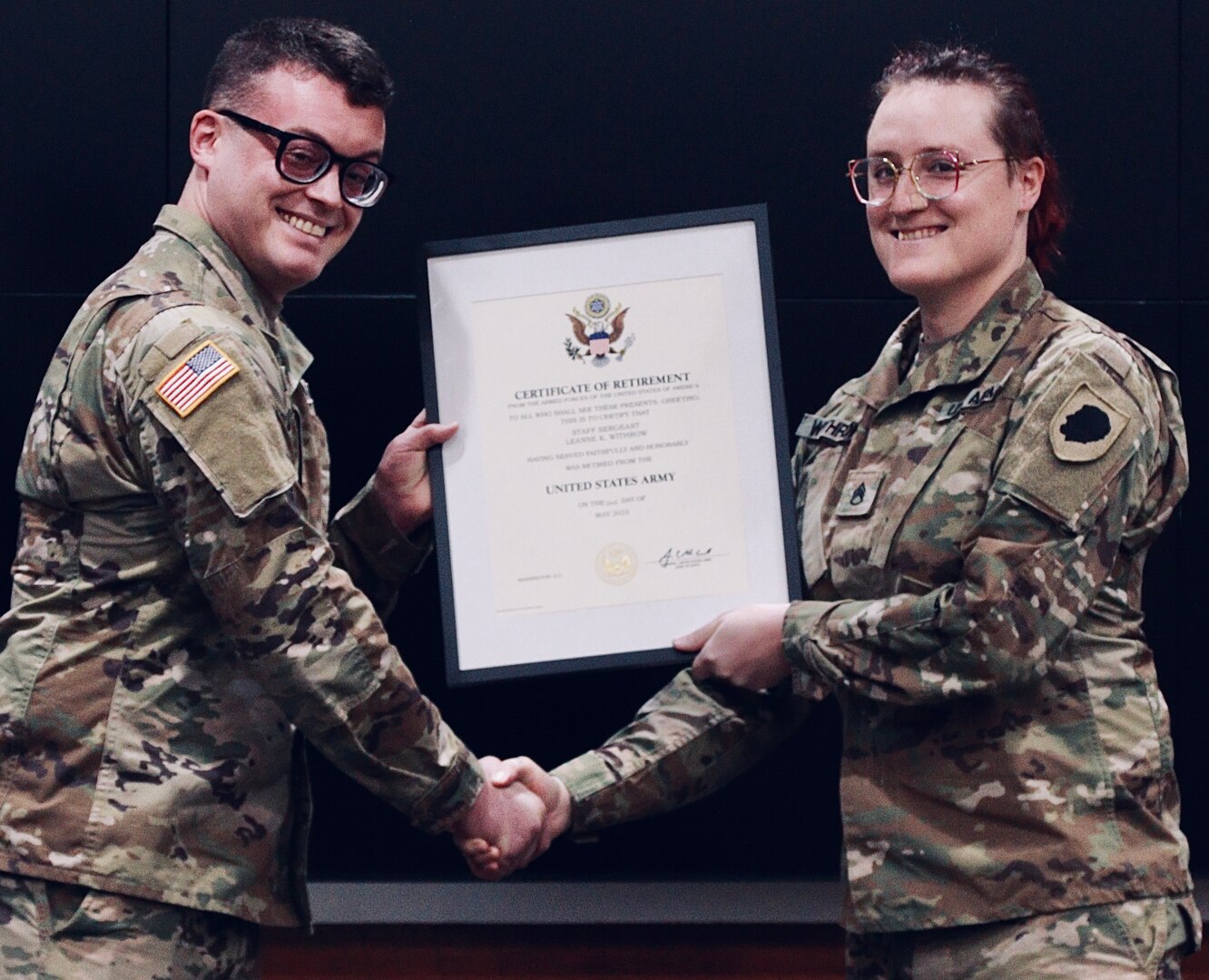 Army Reserve 1st Lt. Colin Withrow of the 484th Forward Engineer Support Team presents his sister, Illinois Army National Guard Staff Sgt. LeAnne Withrow, with a Certificate of Retirement during Staff Sgt. LeAnne Withrow's retirement ceremony.