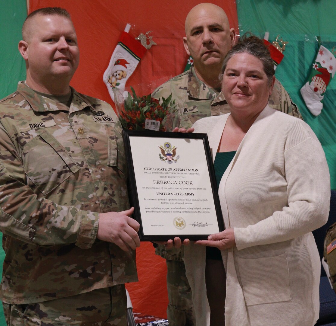 Becky Cook, the spouse of Illinois Army National Guard Chief Warrant Officer 3 Joseph Cook of Lincoln, Illinois, accepts a plaque from the Army Chief of Staff in recognition of her service and dedication to the nation up her husband's military retirement.