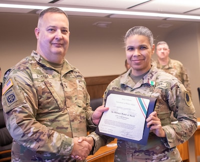 Brig. Gen. Mark Alessia, of Sherman, Illinois, Director of the Illinois National Guard Joint Staff, presents Capt. Crystal Rodrigues, of Pawnee, Illinois, Director of the Illinois National Guard State Partnership Program, with the Illinois Military Medal of Merit at a ceremony Dec. 5 at Joint Force Headquarters, Camp Lincoln, Springfield, Illinois.