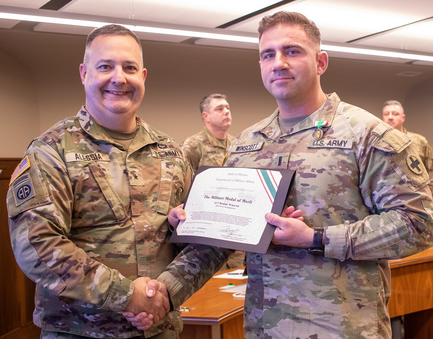 Brig. Gen. Mark Alessia, of Sherman, Illinois, Director of the Illinois National Guard Joint Staff, presents 1st Lt. Benton Winscott, of Chillicothe, Illinois, Strategic Plans and Policy Officer for the Illinois National Guard Joint Staff, with the Illinois Military Medal of Merit at a ceremony Dec. 5 at Joint Force Headquarters, Camp Lincoln, Springfield, Illinois.
