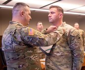 Brig. Gen. Mark Alessia, of Sherman, Illinois, Director of the Illinois National Guard Joint Staff, presents 1st Lt. Benton Winscott, of Chillicothe, Illinois, Strategic Plans and Policy Officer for the Illinois National Guard Joint Staff, with the Illinois Military Medal of Merit at a ceremony Dec. 5 at Joint Force Headquarters, Camp Lincoln, Springfield, Illinois.