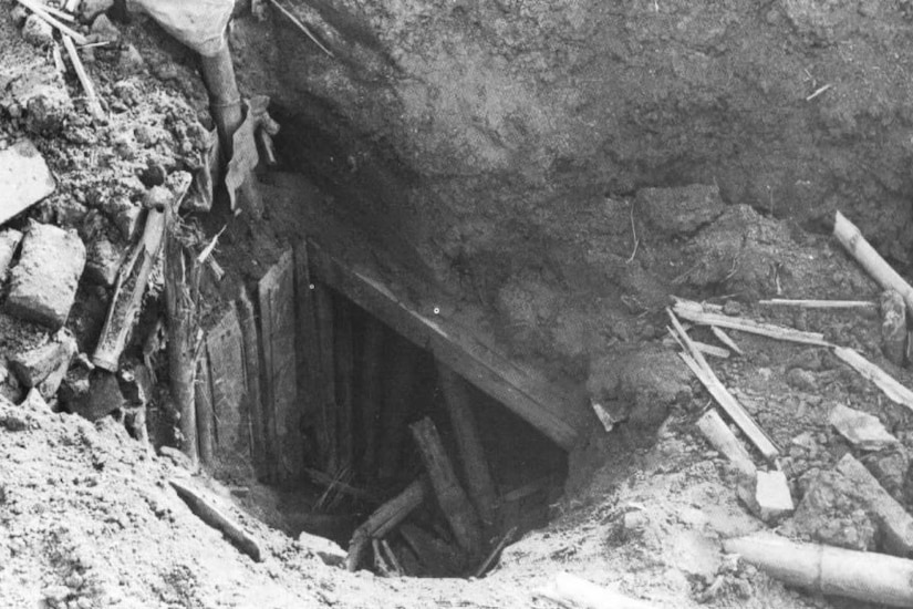 The entrance to a bunker is visible several feet below ground.