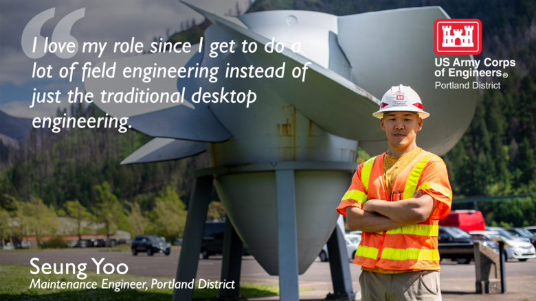 Man stands in front of a turbine with U.S. Army Corps of Engineers Safety vest and helmet.