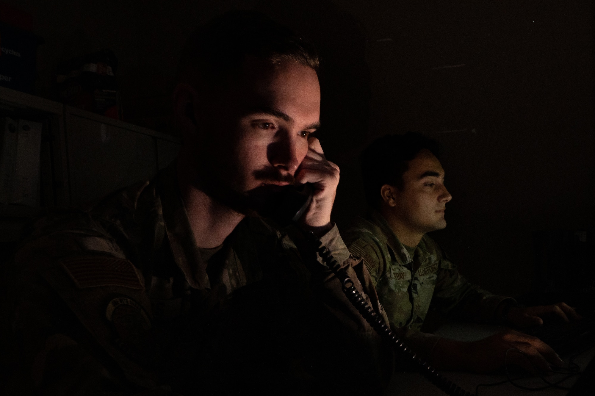 U.S. Air Force Staff Sgt. Joseph Gross, the noncommissioned officer in charge of cyber requirements, for the 6th Communications Squadron, and Senior Airman Tristan Westbay, a cyber transport systems specialist assigned to the 6th CS, answer phones at MacDill Air Force Base, Florida, Dec 1, 2023.