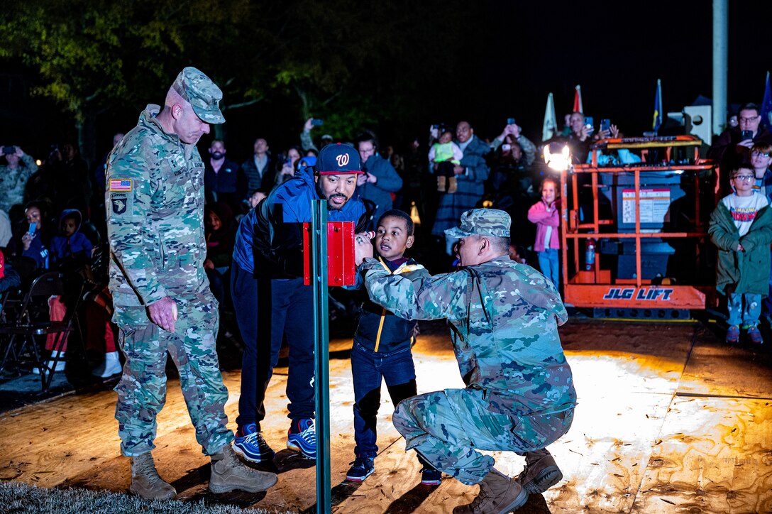 U.S. Army Maj. Gen. John Kline, U.S. Army Center of Initial Military Training commanding general (left) and Col. Frankie Cochiaosue, 733d Mission Support Group commander, light the Ft. Eustis Holiday Tree with Nasir Simpson and his dad during the annual Fort Eustis Holiday Tree Lighting at Joint Base Langley-Eustis, Virginia, Dec. 1, 2023.