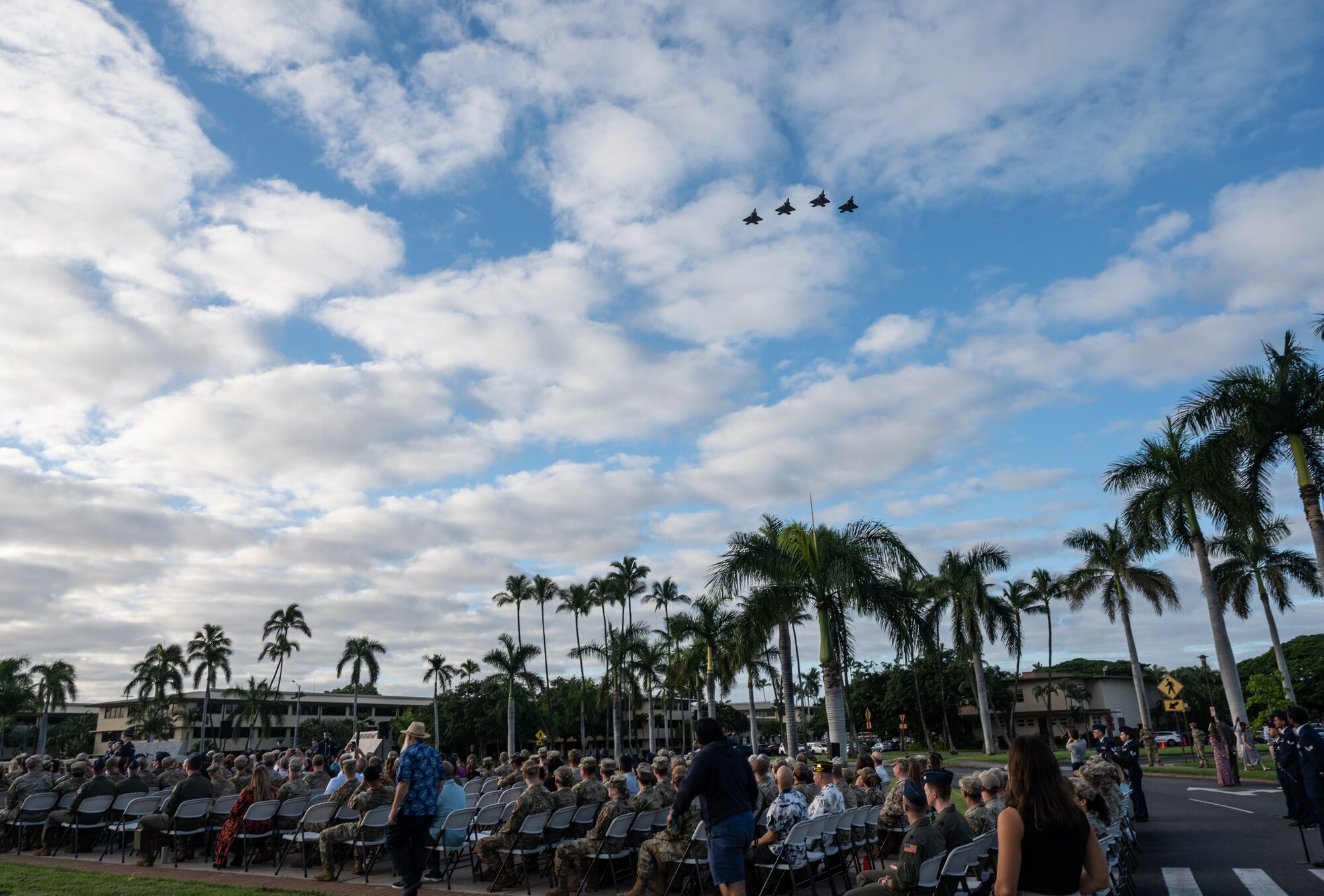 Service members, family and friends view a flyover during a December 7th Remembrance Ceremony at Joint Base Pearl Harbor-Hickam, Hawaii, Dec. 7, 2023. This was the 82nd anniversary of the attacks on Pearl Harbor and Hickam Field that claimed the lives of 189 service members. (U.S. Air Force photo by Staff Sgt. Alan Ricker)