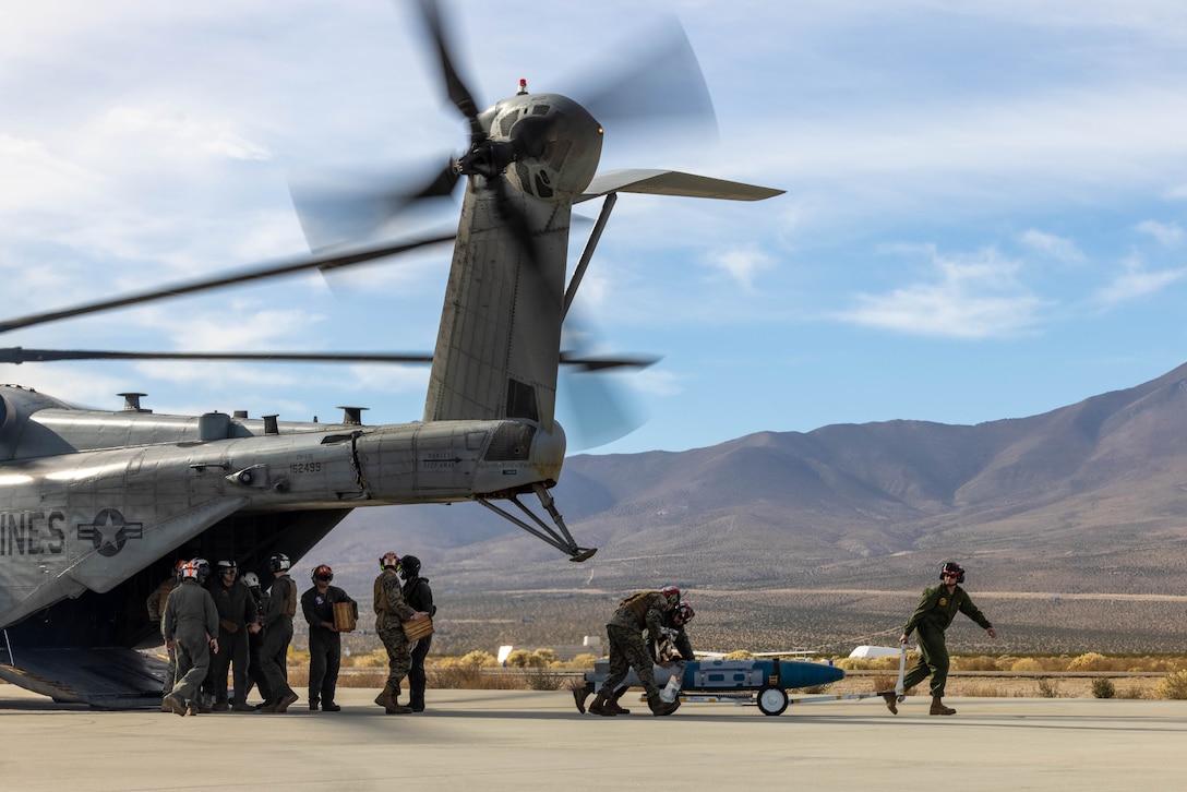 U.S. Marines with the 3rd Marine Aircraft Wing All Type Model Series Armament Team unload ordnance from a CH-53E Super Stallion helicopter at a forward arming and refueling point in support of Exercise Steel Knight 23.2 at Inyokern Airfield, California, Dec. 2, 2023. ATAT is comprised of aviation ordnance Marines qualified to load and arm every type model series platform in the 3rd MAW fleet. Steel Knight 23.2 is a three-phase exercise designed to train I Marine Expeditionary Force in the planning, deployment and command and control of a joint force against a peer or near-peer adversary combat force and enhance existing live-fire and maneuver capabilities of the Marine Air-Ground Task Force. (U.S. Marine Corps photo by Lance Cpl. Jennifer Sanchez)