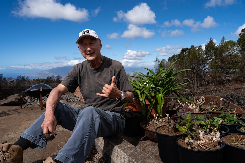 Thomas Liu, who lost his house in the Aug. 8, 2023, Hawaiʻi Wildfires in Kula, Maui, sits next to some plants that survived the fire, Nov. 24, 2023. Liu was one of the first property owners in Kula to have their property cleared of the fire-related debris through the U.S. Army Corps of Engineers debris removal program.