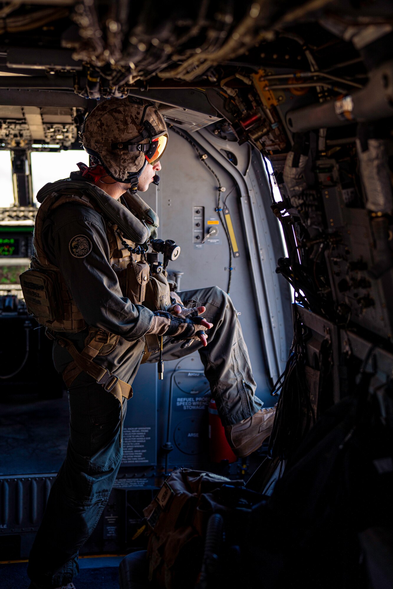 Man looks out of helicopter door.