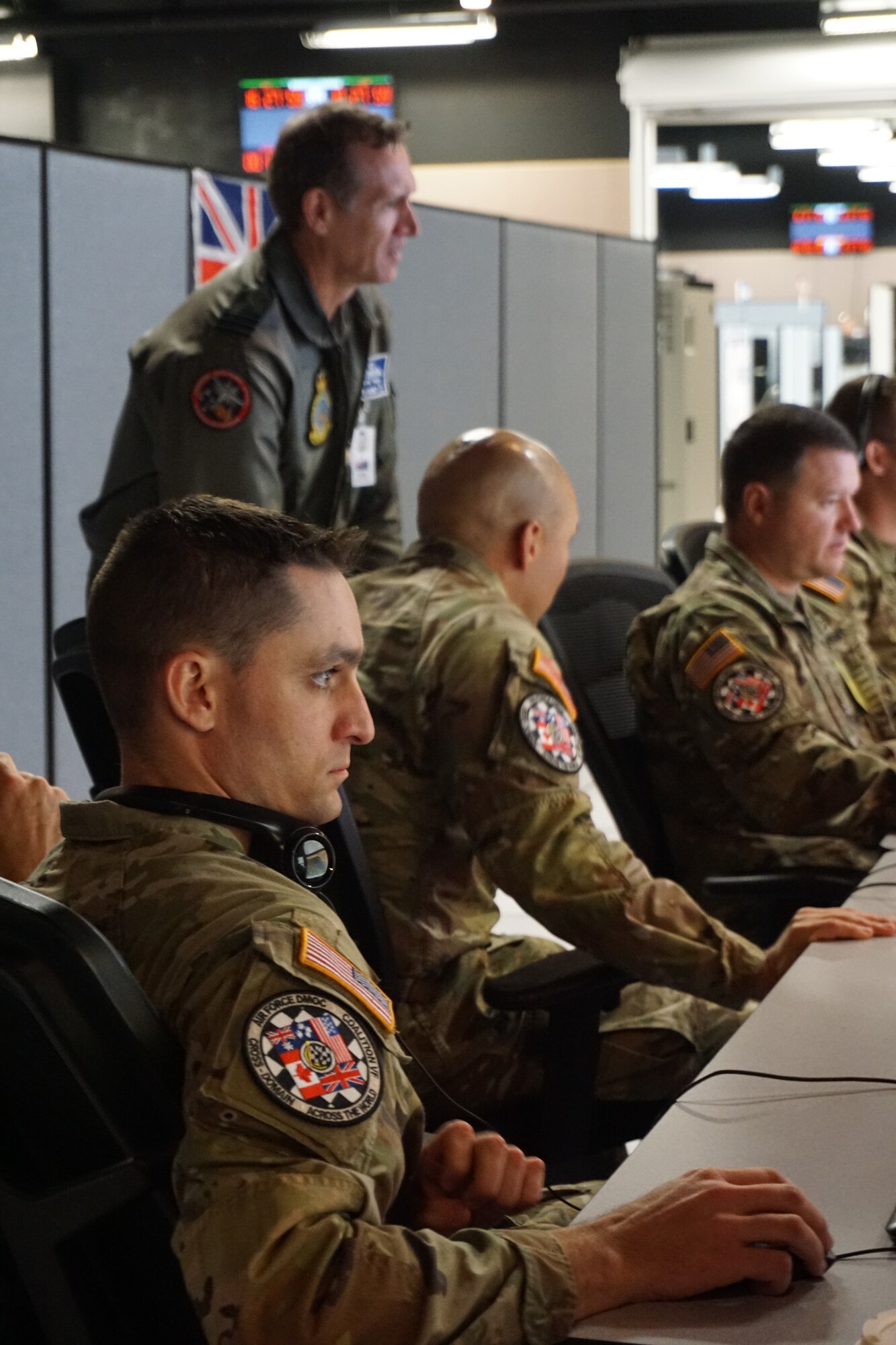uniformed military members work at computers