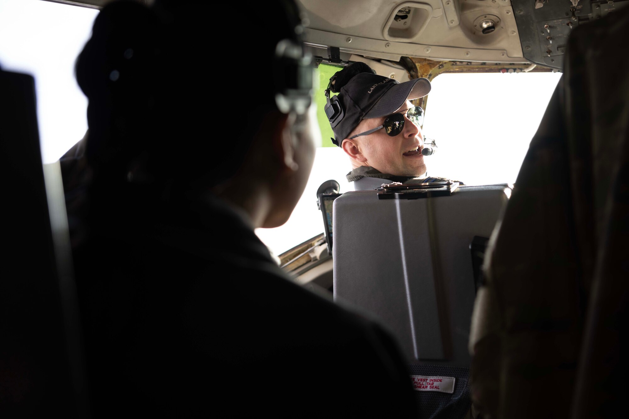 An Airman sits in the copilot seat of a military aircraft