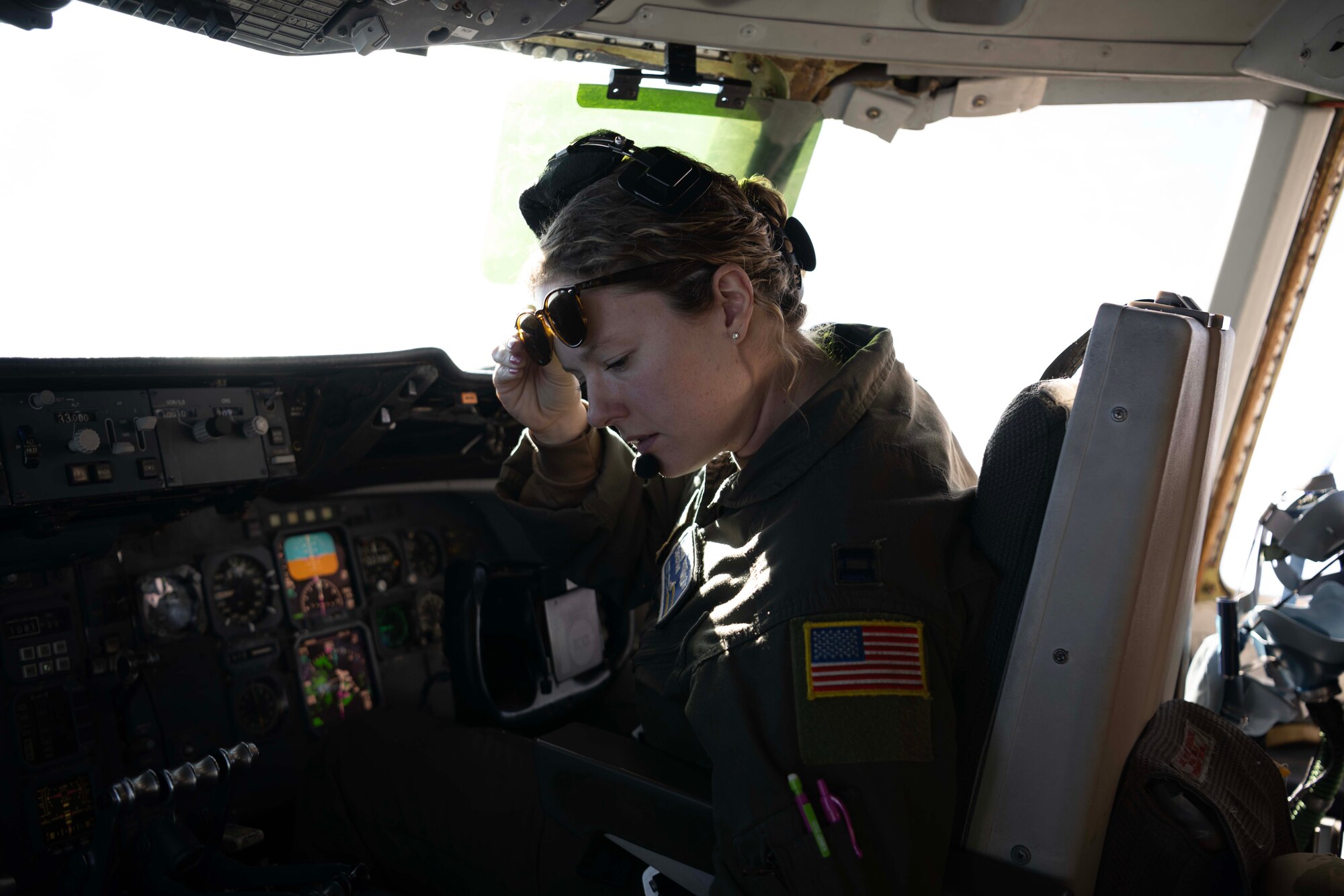 An Airman sits in the pilot seat of a military aircraft