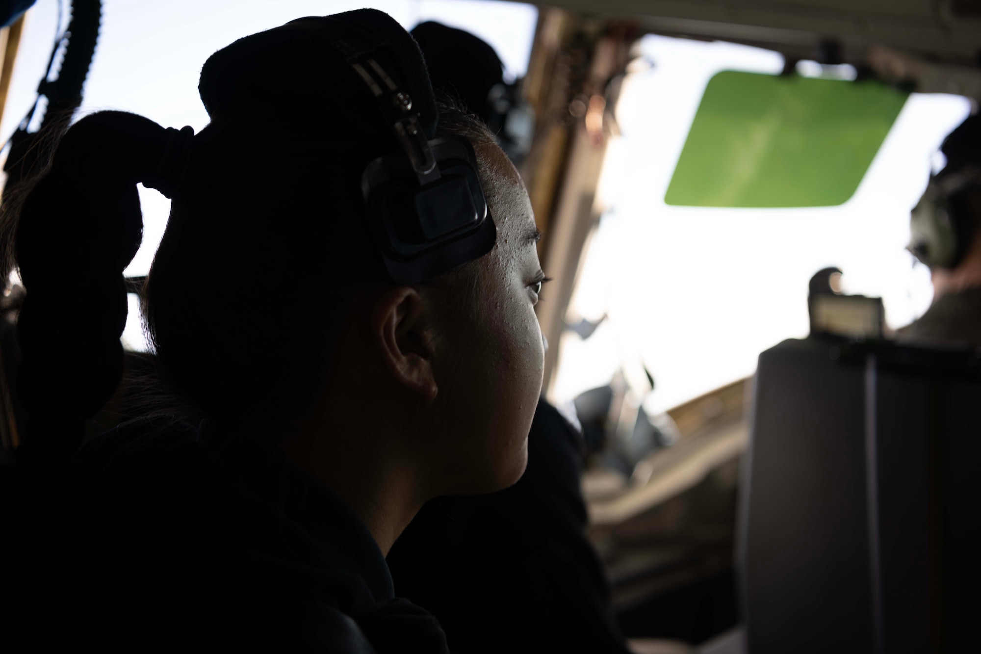 An Air Force cadet sits in the flightdeck of a military aircraft