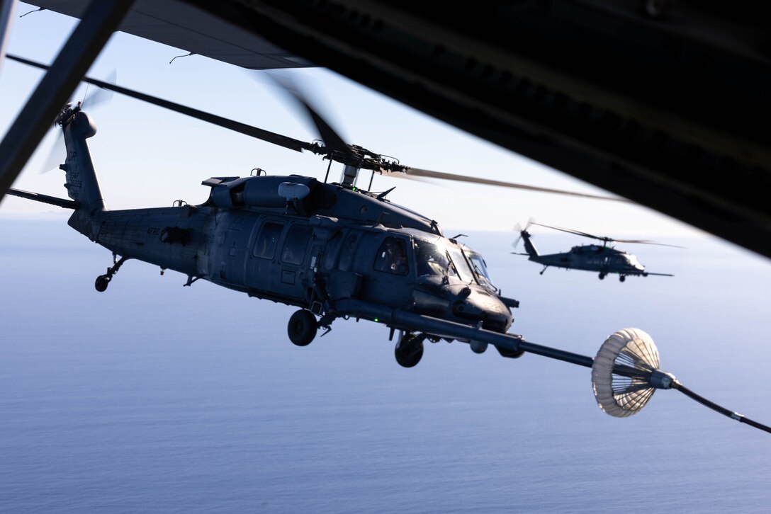 A U.S. Air Force HH-60G Pave Hawk aircraft with 301st Rescue Squadron, 920th Rescue Wing, receives fuel from a HC-130J Combat King II aircraft with 39th Rescue Squadron, 920th RW, during joint combat search and rescue training in support of Exercise Steel Knight 23.2 off the coast of San Diego, California, Dec. 5, 2023. Steel Knight 23.2 is a three-phase exercise designed to train I Marine Expeditionary Force in the planning, deployment and command and control of a joint force against a peer or near-peer adversary combat force and enhance existing live-fire and maneuver capabilities of the Marine Air-Ground Task Force. (U.S. Marine Corps photo by Lance Cpl. Jennifer Sanchez)