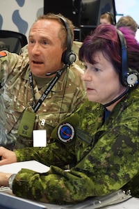 Alt text: uniformed military members working at computers