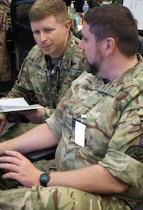 Alt text: uniformed military members working at computers