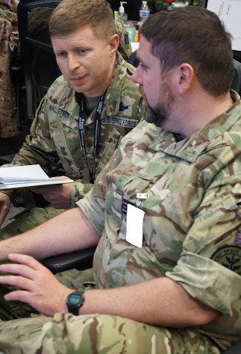 Alt text: uniformed military members working at computers