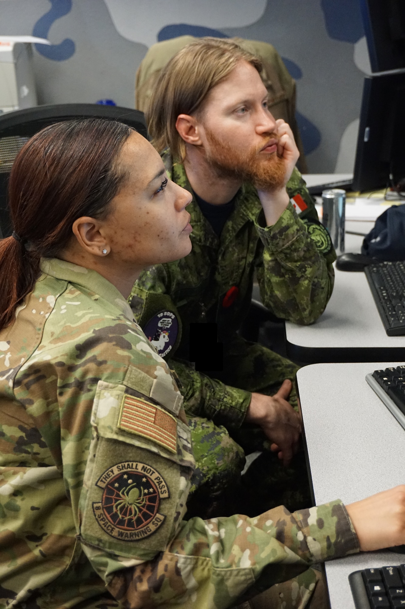 Alt text: uniformed military members work on computers