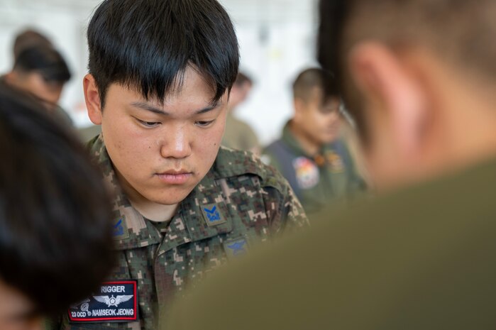 Photo of a Republic of Korea Air Force noncommissioned officer helping bundle an Operation Christmas Drop.