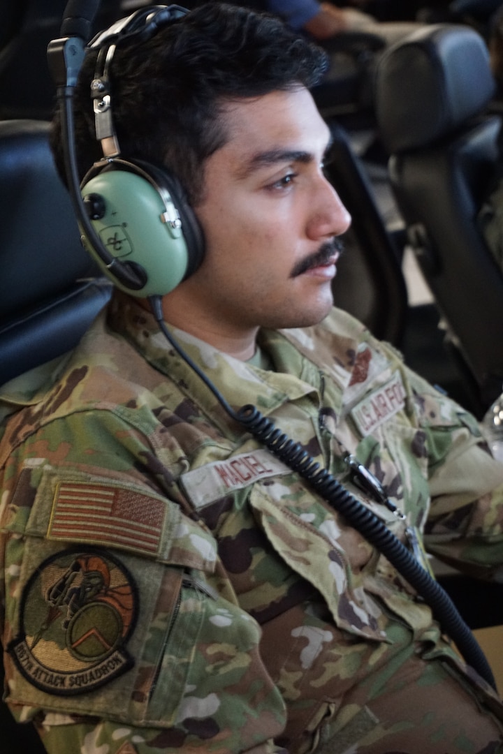 uniformed military pilot flys an MQ-9 simulator