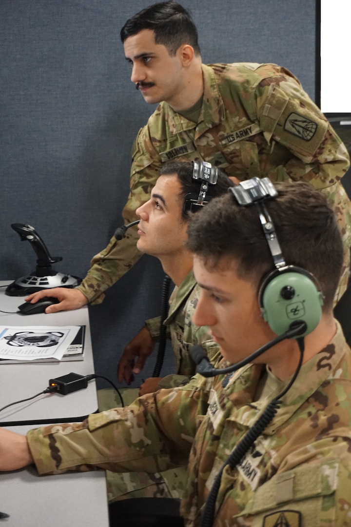 Alt text: uniformed military members work on computers