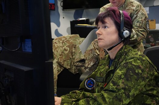 uniformed military members working  computers