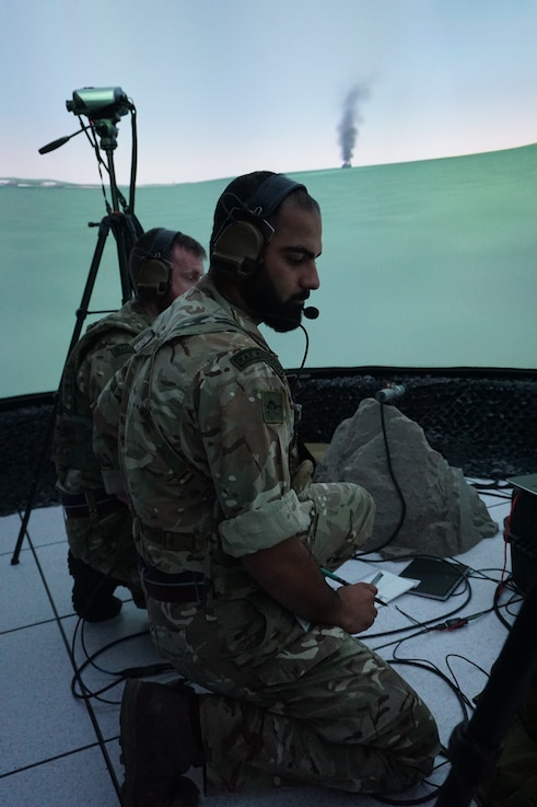  Alt text:  uniformed coalition forces work in a virtual simulated environment
