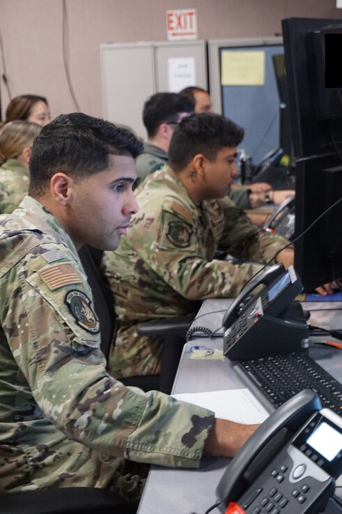  uniformed military members working at computers