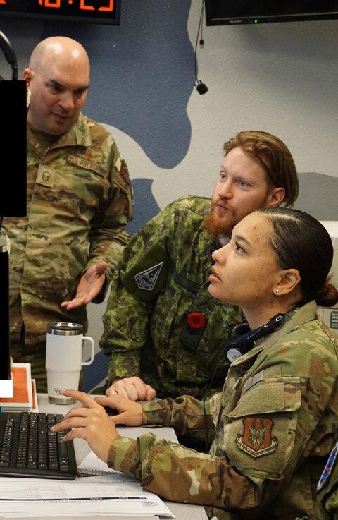  uniformed military members working  computers